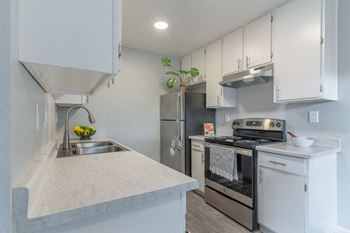 a kitchen with stainless steel appliances and white cabinets at The Gates at The Marina Apartments, California, 93933